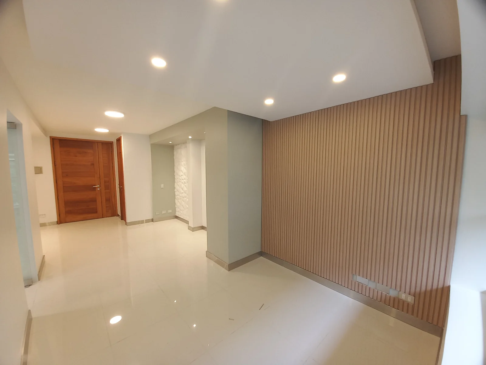 Pasillo de una clínica dental con muro de listones de madera y puertas de madera